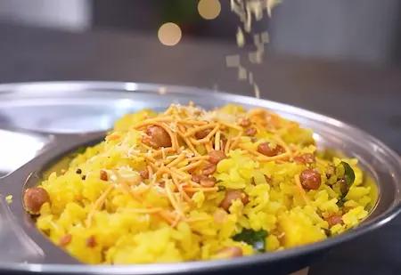 Cooking poha with boiled potatoes, peanuts, and spices for Nagpur Special Tari Poha