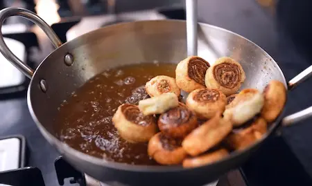 Frying the Easy Mini Bhakarwadi pieces in hot oil until golden brown