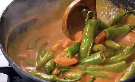 Step 5 adding curd mixture and tomatoes for dahi mirchi ki sabji