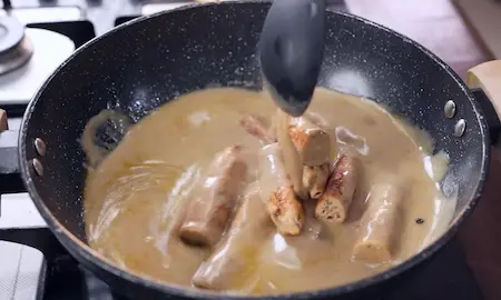 Step 7: Simmering cooked chicken seekh in malai gravy for Afghani Malai Chicken Seekh