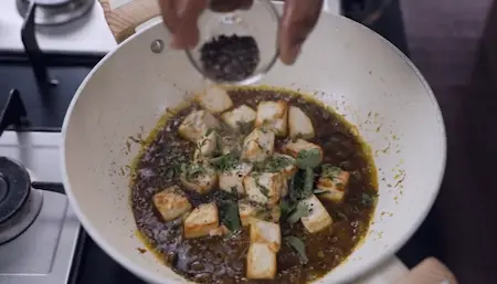 Step 3: Adding fried paneer to masala with curry leaves for Paneer Pepper Fry