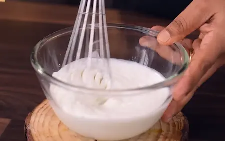 Step 6: Whisking sweetened curd with cream for Sindhi Dahi Mirchi Chaat assembly