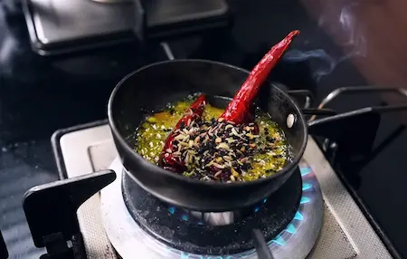 Step 8: Making panch phoran tadka with bay leaf and dry red chilli for Niramish Jhol