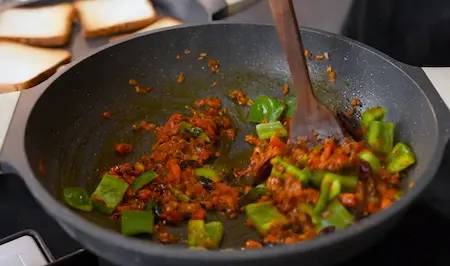 Capsicum and spices being cooked into the masala for Bread Chilli.