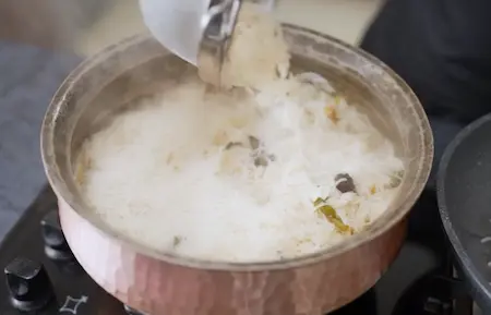 Rice being spread over the yam base