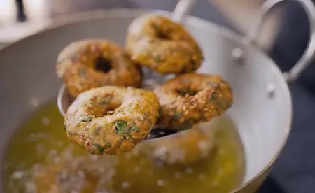 Frying crispy Methi Wada in oil