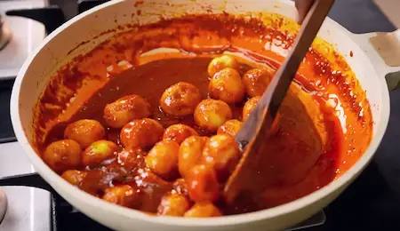 Coating boiled potatoes with masala