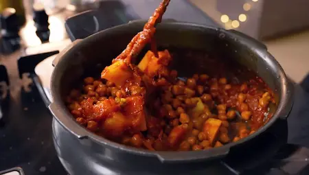 Adding potatoes and chana to the masala