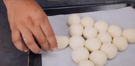 Arranging buns in a Christmas tree shape on a baking tray