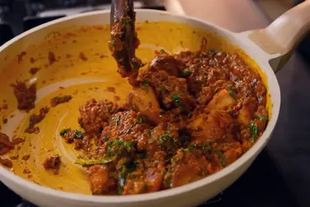 Final Aloo Bhuna dish garnished with coriander and chillies