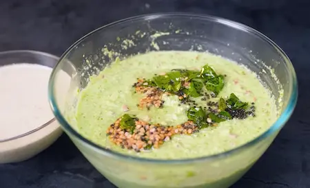 Adding tadka to the idli batter