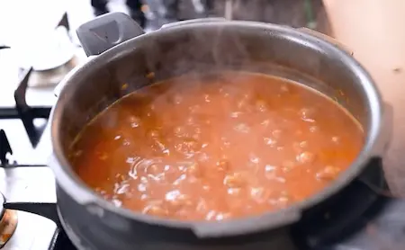 Mashing cooked rajma and finishing with ghee and kasuri methi