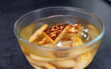 Shallow-fried paneer cubes soaking in warm water