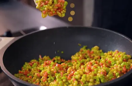 Boondi being mixed with thick sugar syrup for ladoo making