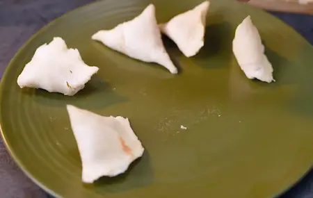 Assembling bread samosas by filling and sealing bread cones