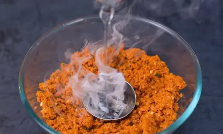 infusing smoke into the soyabean seekh mixture using hot coal and cloves