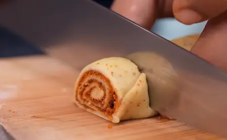 Cutting and shaping the Easy Mini Bhakarwadi roll into small pieces