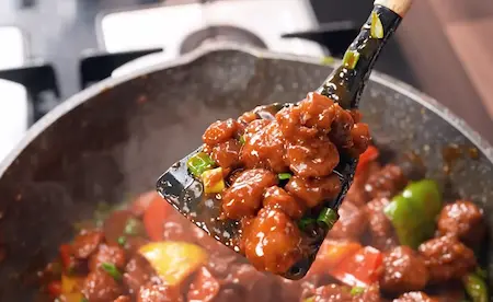 Step 4: tossing crispy soya chunks in spicy soya chilli sauce