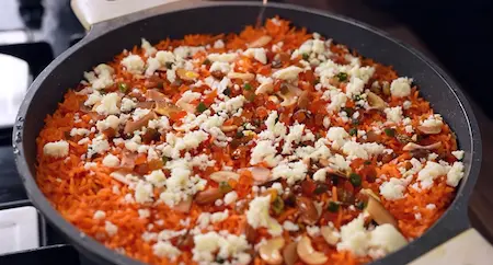 Step 5: adding nuts, saffron milk, khoya, and kewra to Meethe Chawal Recipe