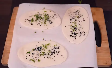 Step 5: Rolling kulcha dough with kalonji and coriander topping for Peepé Wale Chole Kulche