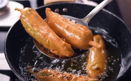 Step 5: Deep frying besan-coated stuffed mirchi vada for Sindhi Dahi Mirchi Chaat