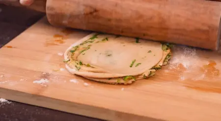 Step 8: Folding and shaping Mirch Laccha Paratha with green chilli and coriander