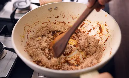 Step 7: Adding crushed peanuts and sesame to Masala Tendli Aloo masala