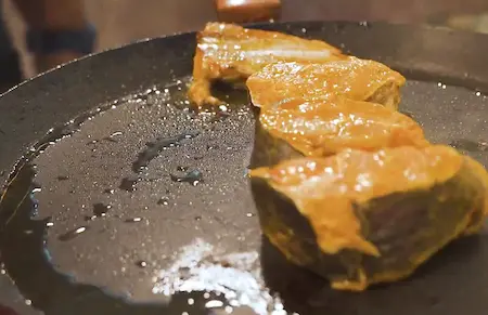 Frying crispy bhetki fish in mustard oil for the curry.