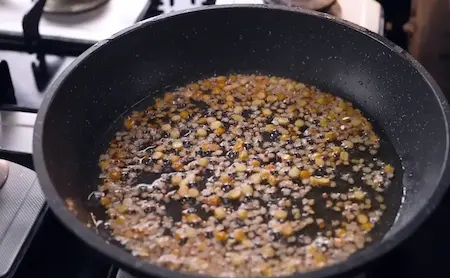 Adding tadka to the Lauki Chila batter