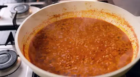 Adding masala paste to the pan