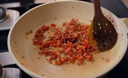 Golden onions and thick tomato gravy in a pan.