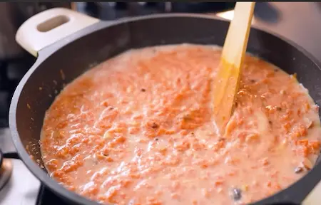 Milk being added to carrot mixture for Gajar Halwa