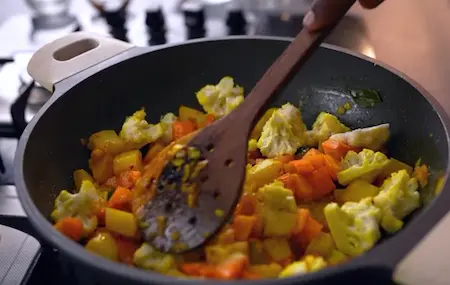 Cooking vegetables like potatoes, carrots, and cauliflower for the gassi.