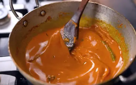 Simmering the korma gravy with green chilies and garam masala