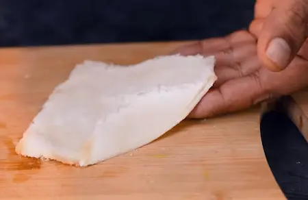 Flattening and cutting bread slices into triangular wrappers