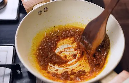 Tempering mustard oil with jeera and red chilli for ghugni