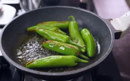 Step 5: Final tempering of Achari Dal with mustard oil, mustard seeds and stuffed Bhavnagri chillies