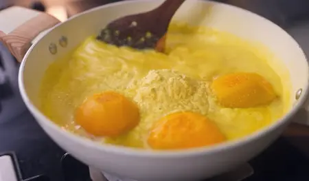 Step 3: Adding fresh coconut paste to cooked mangoes in the pan for Mango Curry