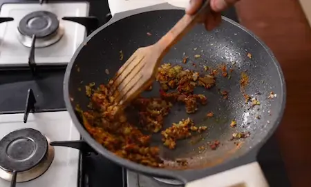 Masala base cooking with spices, onions, ginger-garlic, and green chilli paste.