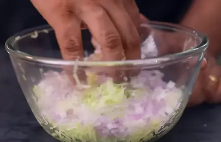 Preparing batter for Lauki Chila with grated lauki and spices