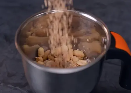 Smooth peanut mixture paste in a grinder.