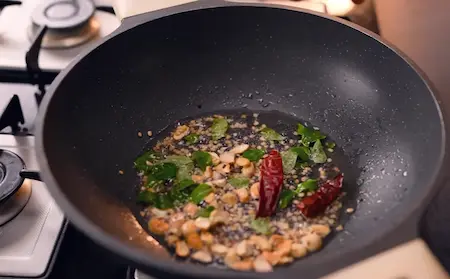 Tempering spices including mustard seeds, curry leaves, and red chilies