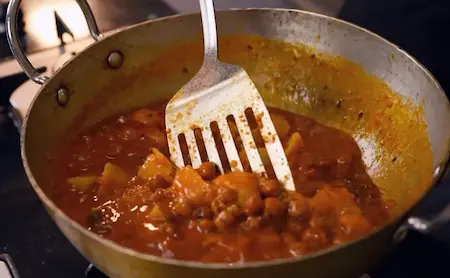 Adding boiled chana and potatoes to Aloo Chana Sabzi