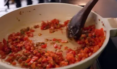 Cooking masala with onions, tomatoes, and spices