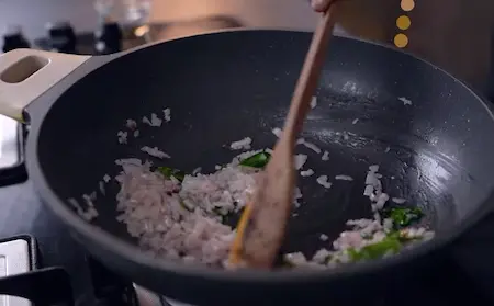 Sautéing curry leaves and onions for the gassi gravy base.