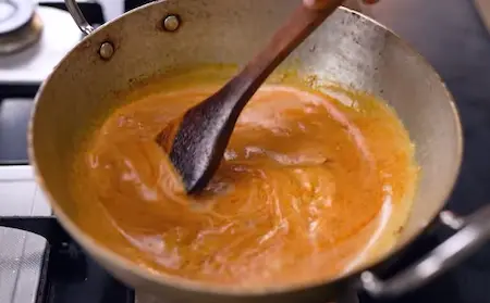 Cooking the korma gravy with spices and cashew paste