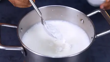 mixing cornflour with cold milk in a bowl for homemade dahi