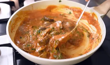 Methi Ringan Nu Shaak being prepared with sautéed methi leaves and eggplant slices