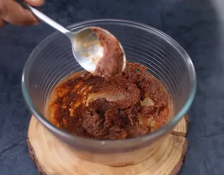 Mixing tamarind chutney and Dabeli masala to make filling for Dabeli Pakoda Sandwich