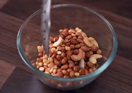 Step 1: frying peanuts, cashews, and coconut for Poha Chiwda Recipe